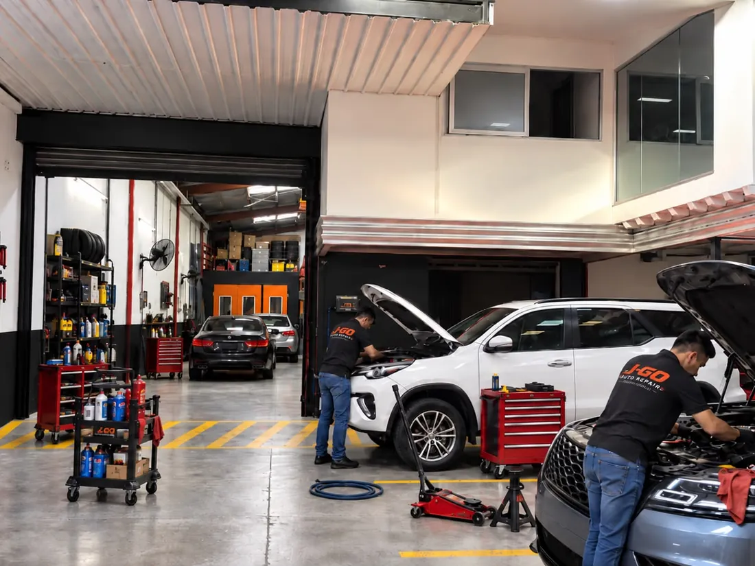 Área de servicio de J-GO Auto Repair vista desde la entrada, con técnicos atendiendo vehículos
