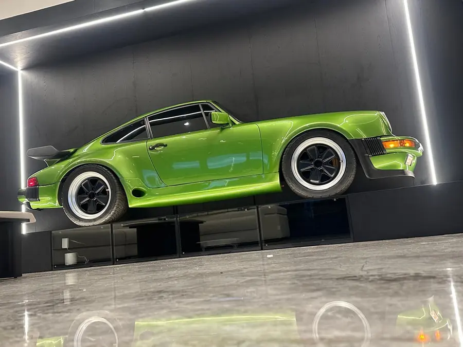 Porsche 911 verde montado sobre panel iluminado