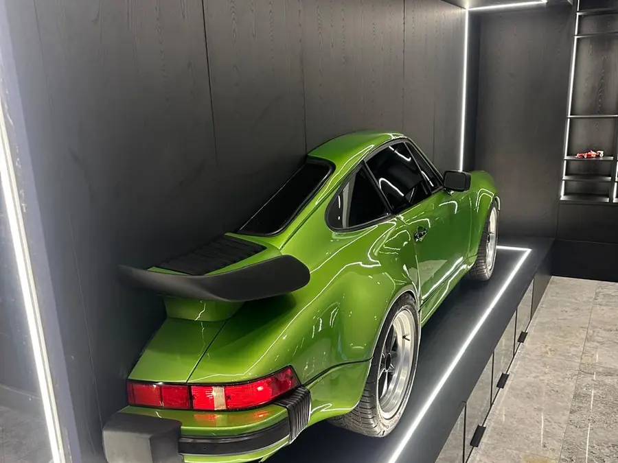 Porsche 911 verde visto desde atrás sobre el panel